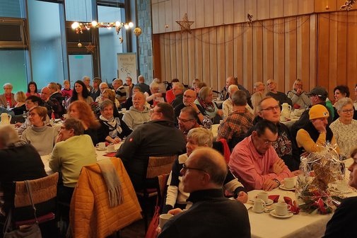 Viele Menschen sitzen an den Tischen