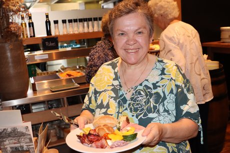 Tolles Frühstücksbuffett eine Dame hält einen Teller mit Frühstückscerealien in die Kamera