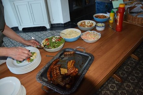 Foto des Buffets mit verschiedenen Salaten und einer Platte mit Grillgut.