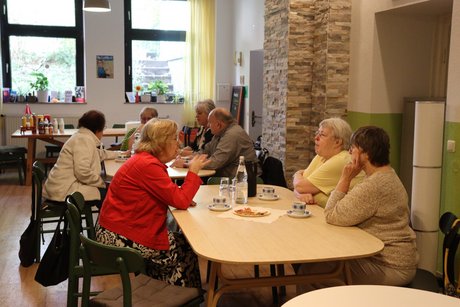 Mitglieder und Gäste des Ortsverband. Mehrere Personen sitzen an Tischen und unterhalten sich.