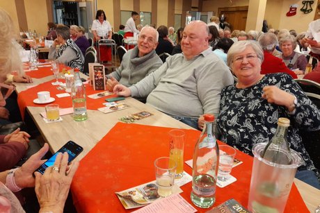 Mitglieder und Gäste in Clemens August. Jubilar-Ehrung, eine Person gibt etwas an eine andere Person.