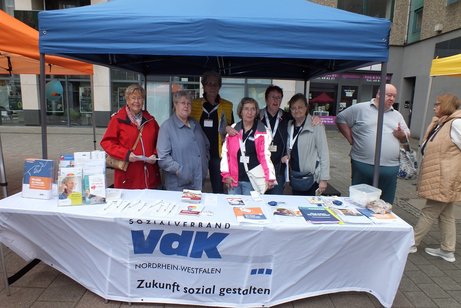 Mehrere Menschen stehen hinter einem VdK Info-Stand.