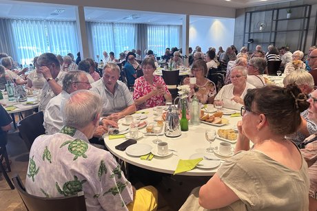 Sommerfest Mitglieder sitzen an den Tischen und genießen den Kaffee, Kuchen und s