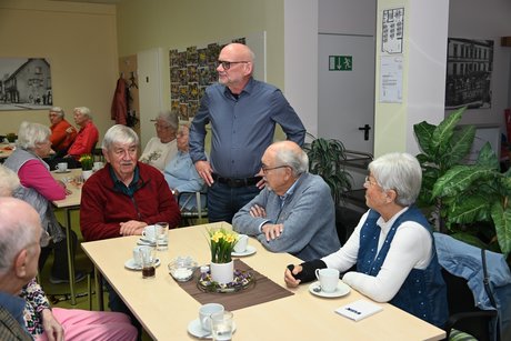 Mitglieder sitzen am Tisch bei einer Unterhaltung