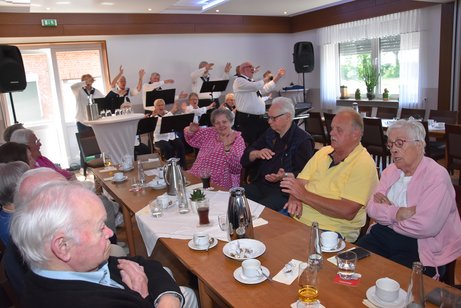 Mitglieder des VdK OV Emsdetten singen, schunkeln und klatschen gemeinsam mit dem Shanty Chor Emsfähre aus Saerbeck