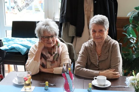 Frühlingsfest Zwei Frauen sitzen am Tisch und lächeln in die Kamera.