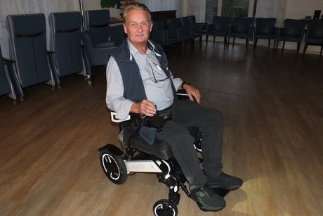 Ein Mann sitzt in einem elektrischen Rollstuhl