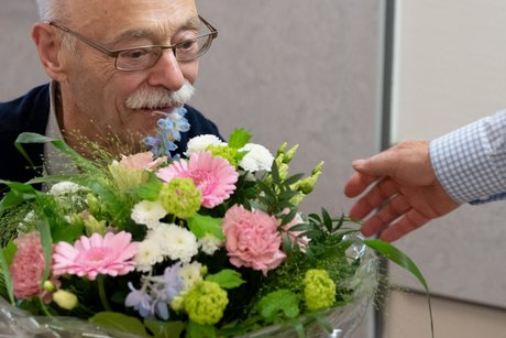 VdK-NRW-Pr&auml;sident Horst V&ouml;ge mit einem Blumenstrau&szlig; mit wei&szlig;en, rosa und hellblauen Bl&uuml;ten.