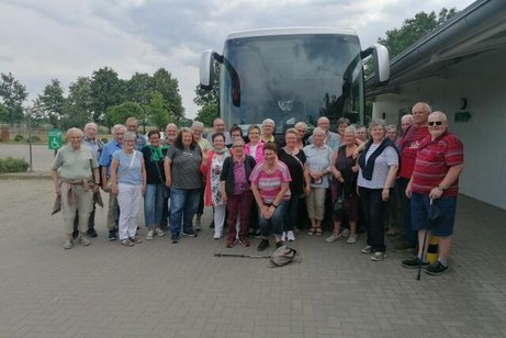 Gruppenfoto mit einer großen Reisegruppe vor einem Reisebus