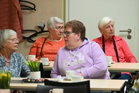 Mitglieder sitzen an einem Tisch und unterhalten sich
