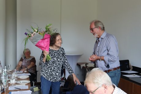Jahreshauptversammlung 2026 Eine Frau hat Blumen von einem Mann als Dank erhalten.