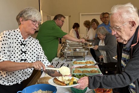 Sommerfest 2026 Gäste bekommen Essen auf Tellern gereicht