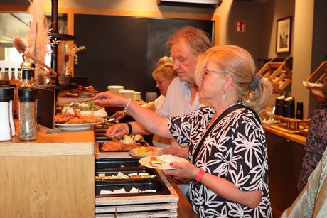 Frühstücksbuffett Personen greifen beim Frühstücksbuffett zu