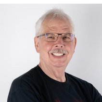 Mann mit grauen Haaren, Oberlippenbart und Brille