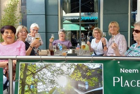 Frauen sitzen gemeinsam an einem Tisch auf der Außenterrasse eines Restaurants