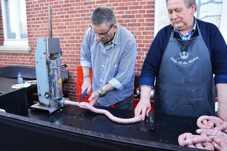 Zwei Fleischer stellen eine Bratwurst her