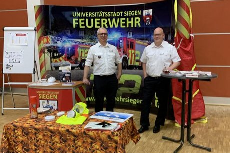 Das Bild zeigt zwei Vertreter der Berufsfeuerwehr am Messestand