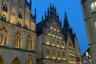 Beleuchtete Rundbögen und Passagen der Giebelhäuser in der Altstadt von Münster.