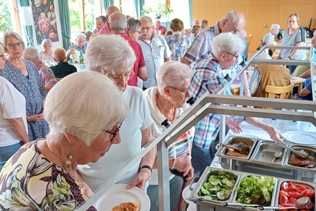 Mitglieder stehen am Buffet an