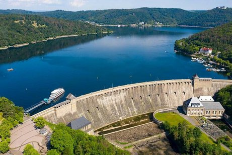Luftaufnahme der Talsperre Edersee und der umliegenden, bewaldeten Hügel.