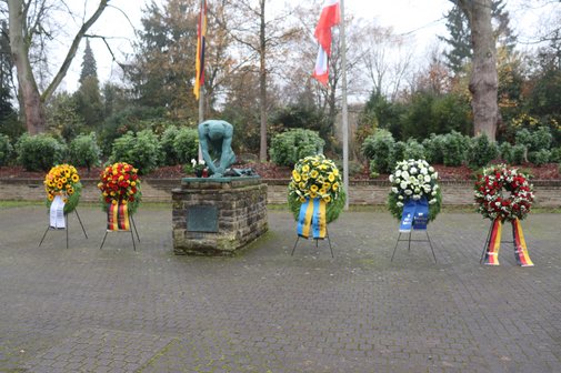 Kranzniederlegung zum Volkstrauertag. 5 Kränze stehen neben der Gedenkstätte der Stadt Essen für die Opfer von Krieg und Gewalt.