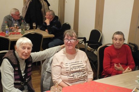 Drei Frauen sitzen an einem Tisch.