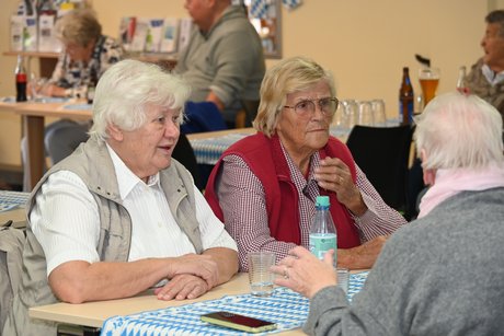 Mitglieder sitzen an einem Tisch bei einer Unterhaltung