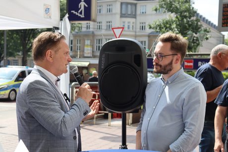 Zwei Männer mit Mikrophon im Gespräch.
