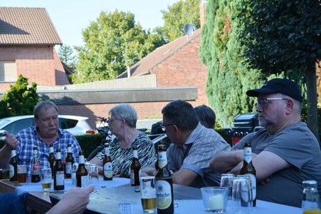 Menschen sitzen mit Kaltgetränken an einem Tisch.