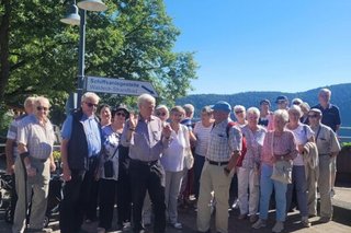 Ein weiteres Gruppenfoto der Reisegruppe vor einem großen Baum und strahlendblauem Himmel.