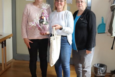3 Frauen stehen zusammen für ein Foto.