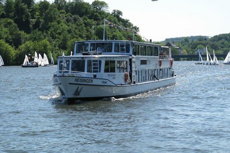 Ein Ausflugsschiff der weißen Flotte nähert sich. Im Hintergrund kreuzen einige Segelschiffe