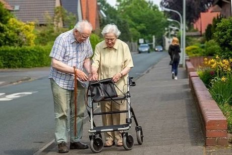 Senioren mir Rollator auf dem Gehweg