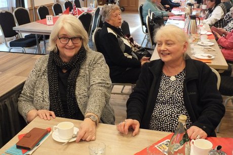 Zwei Frauen sitzen an einem Tisch.