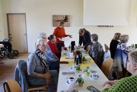 Vertreterinnen der Frauen sitzen an Tischen zusammen.