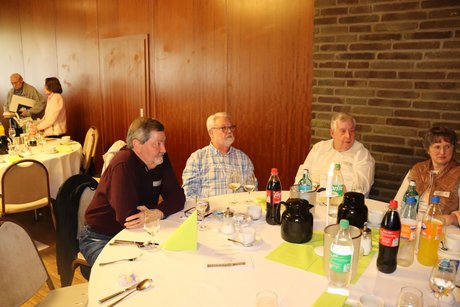 Mehrere Personen sitzen an einem runden Tisch.