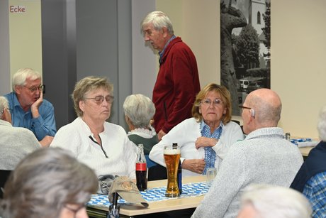 Mitglieder sitzen an einem Tisch bei einer Unterhaltung