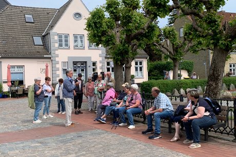 Schleswig Menschen stehen und sitzend bei Stadtführung