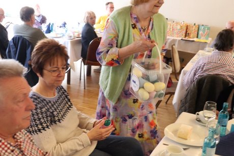 Eine Frau verteilt Ostereier an die Mitglieder .