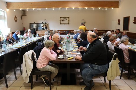 An drei langen Tischen sitzen Mitglieder des VdK Ortsverband.