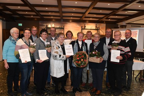 VdK-Kreis-Vorstandsmitglied Eveline Gerdes (6.v.l.) hält die Urkunde für Cäcilia Gildehaus (6.v.r.), die die Goldene Verdienstnadel für 26 Jahre Vorstandsarbeit erhielt. 500. Mitglied ist Christa Maaßmann (4.v.r.). | Foto: Heinrich Weßling