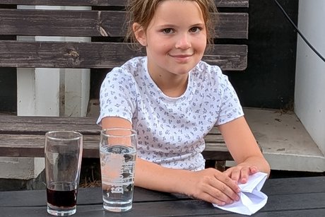 Kleine Pause Ein Mädchen sitzt am Tisch