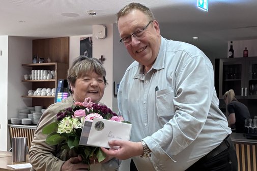 Dirk Schilder &uuml;berreicht Reinhilde Zittlau bei der Verabschiedung einen Blumenstrau&szlig;