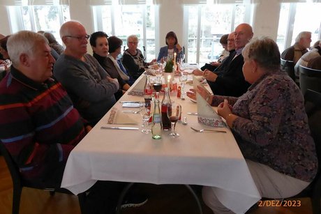Eine Gruppe Menschen sitzt gemeinsam an einem Tisch.