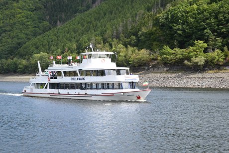 Unser Schiff Ein weisses Ausflugsschiff auf dem See. im Hintergrund schöne grüne Bäume