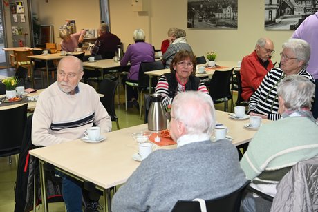 Mitglieder sitzen an einem Tisch und unterhalten sich