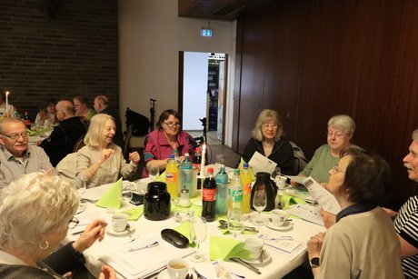 Mehrere Personen sitzen an einem Tisch.