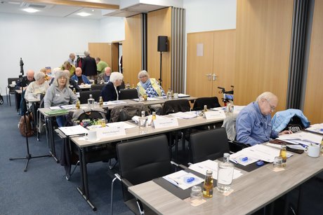 Mehrere Delegierte sitzen an langen Tischen.