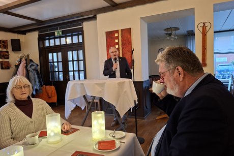 Stellvertretender B&uuml;rgermeister am Pult bei der Begr&uuml;&szlig;ungsansprache. Vorsitzender Klaus Meiers am Tisch.