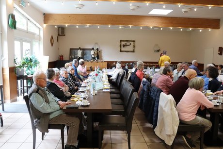 Mehrere Mitglieder sitzen an einem langen Tisch.